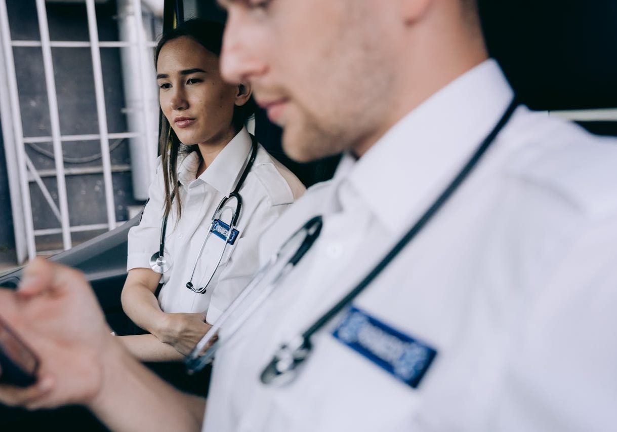 Focused emergency medical technicians discussing a case inside an ambulance.